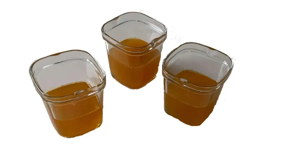 Trois petits pots en verre remplis d'un liquide ambré, prêts à être consommés comme gel énergétique maison.