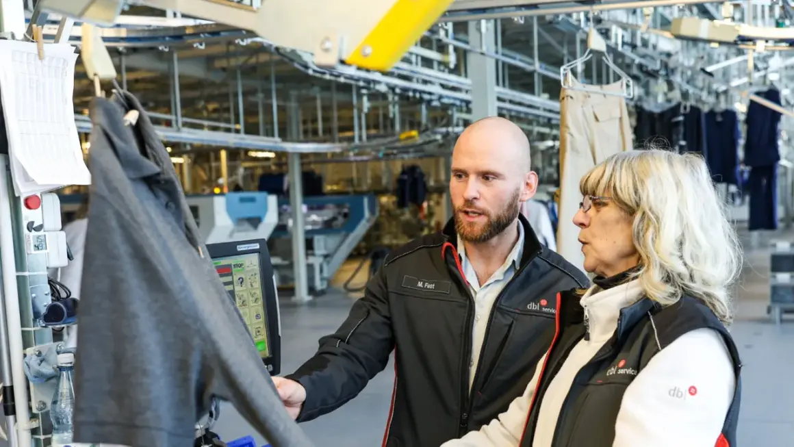 Mitarbeiter besprechen den gwe tarifvertrag bei der Arbeit in einer Wäscherei.