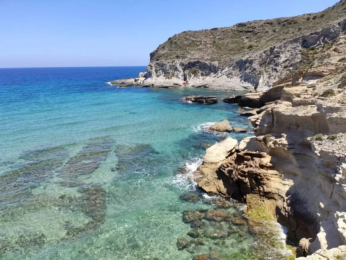 Aguas cristalinas y acantilados rocosos en un día soleado. Un rincón perfecto para unas vacaciones en Cabo de Gata.