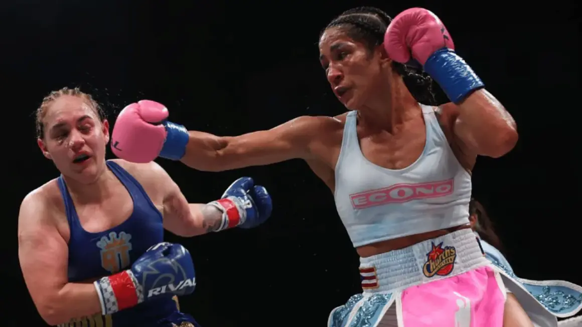 A boxer lands a powerful jab, her opponent reeling from the impact. The intensity of the fight is palpable, showcasing the raw emotion and skill involved in boxing terms.