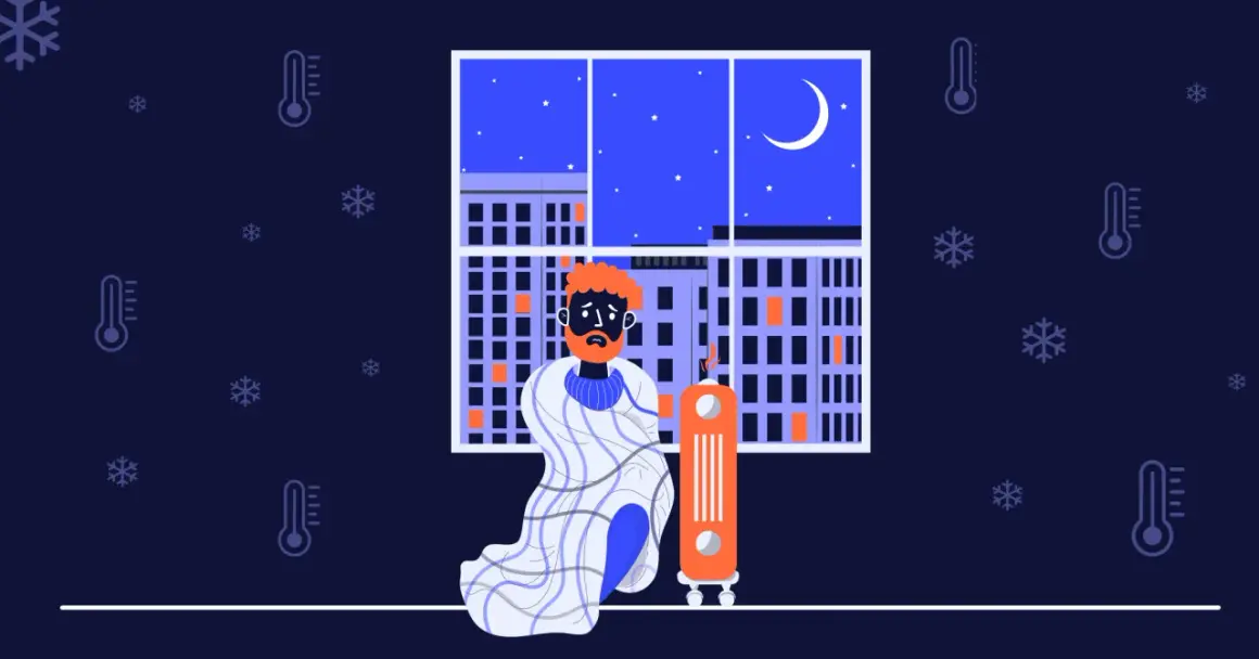 En man med orange hår och skägg sitter insvept i en filt bredvid en element. Utanför fönstret syns en stad i mörker med snöflingor och termometrar som visar att det är kallt i huset.