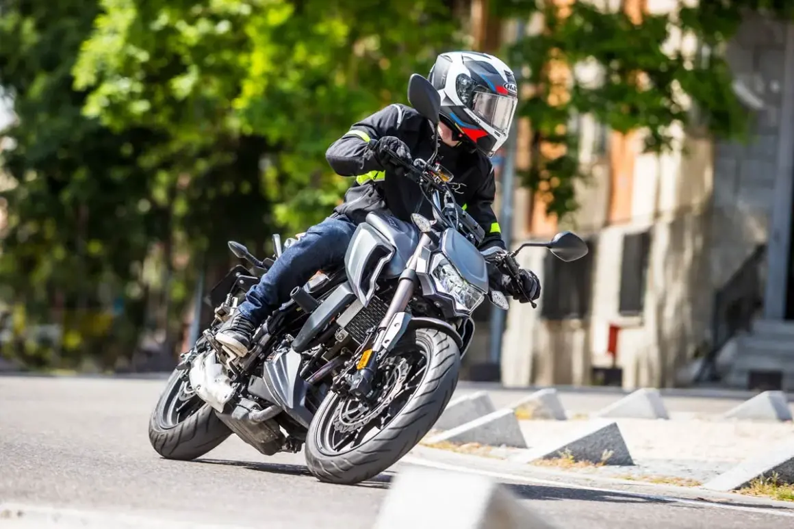 Motociclista en curva con una moto naked. Opiniones sobre la Orcal SK 01 125.