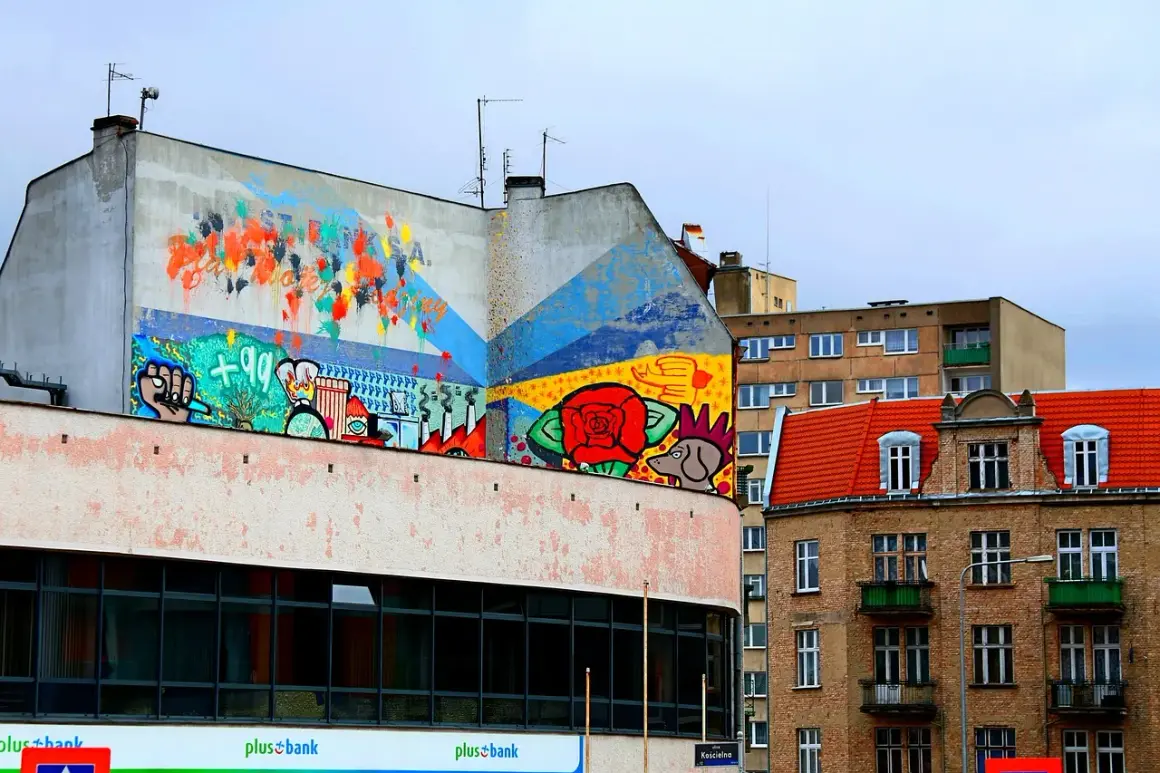 Kolorowy mural na budynku, pełen symboli i abstrakcji, to przykład tego, czym jest postmodernizm w sztuce miejskiej.