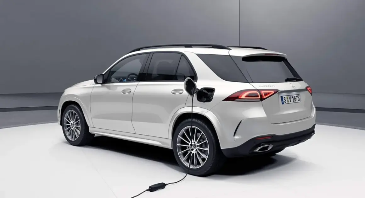 Biały SUV Mercedes-Benz jest ładowany. Zastanawiasz się, czy warto kupić hybrydę? Ten model pokazuje przyszłość motoryzacji.