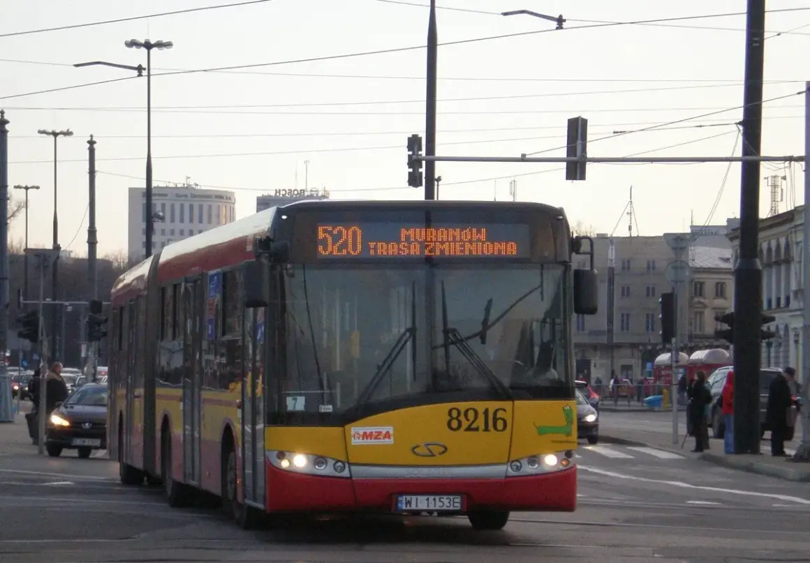 Autobus linii 520 w Warszawie, z informacją "Trasa zmieniona" na wyświetlaczu. Pojazd zbliża się do skrzyżowania.