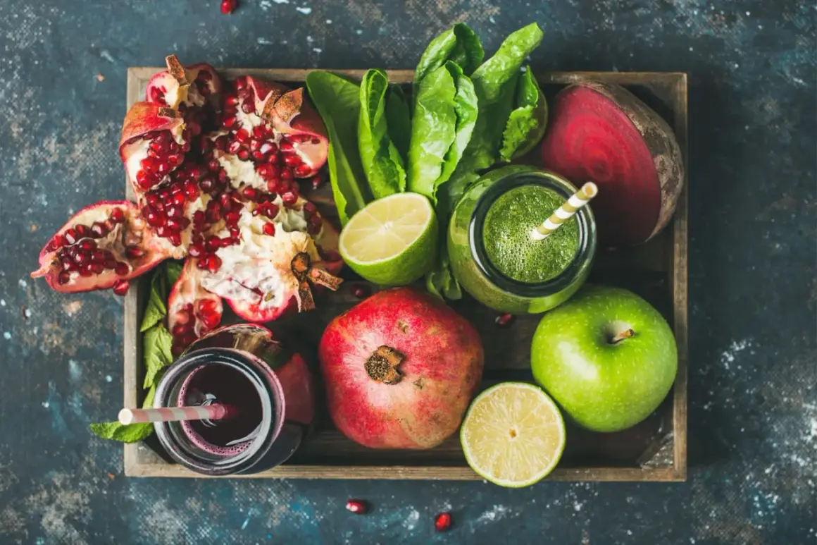 Frische Zutaten für eine **Detox Kur**: Granatapfel, grüner Saft, Rote Bete, Äpfel und Limetten in einer Holzkiste.