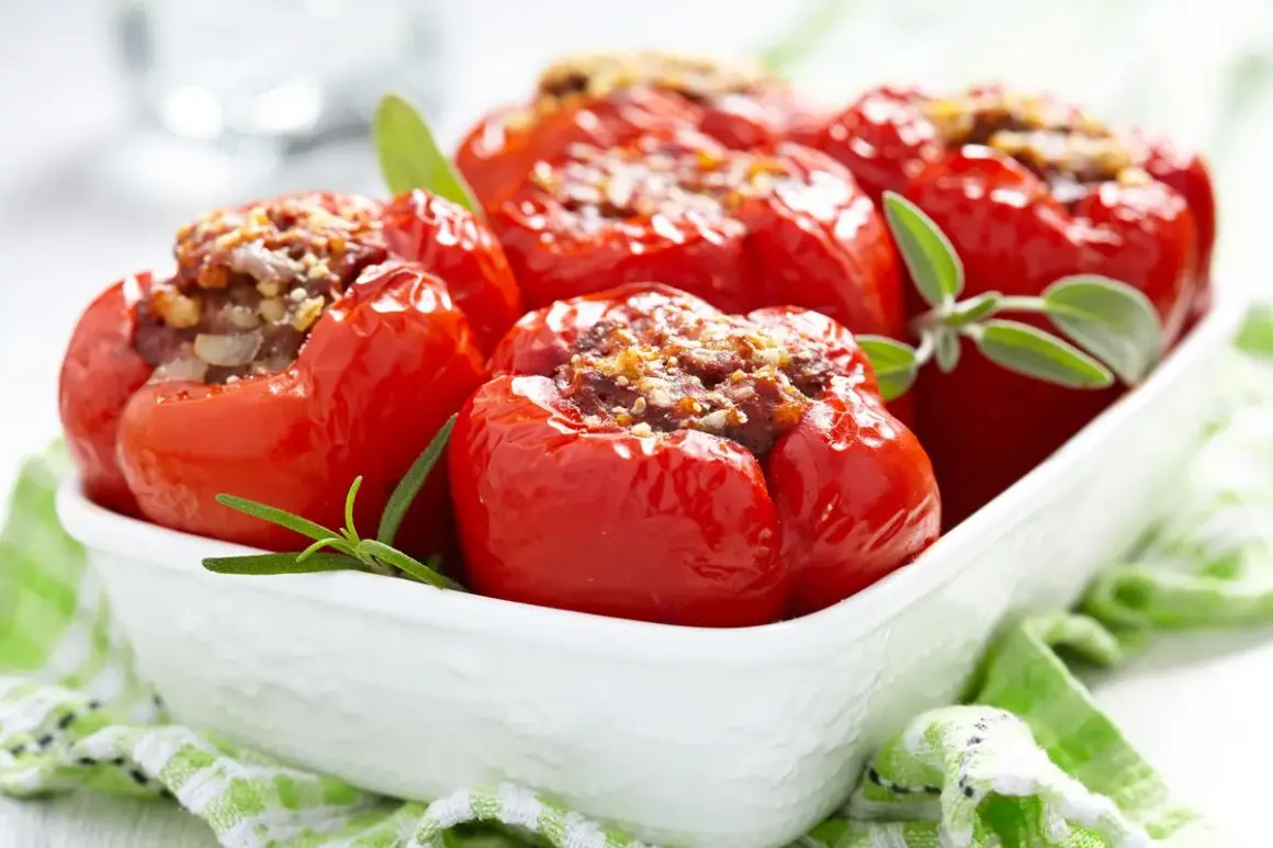 Peperoni ripieni di carne, cotti al forno e guarniti con erbe aromatiche, serviti in una ciotola bianca.