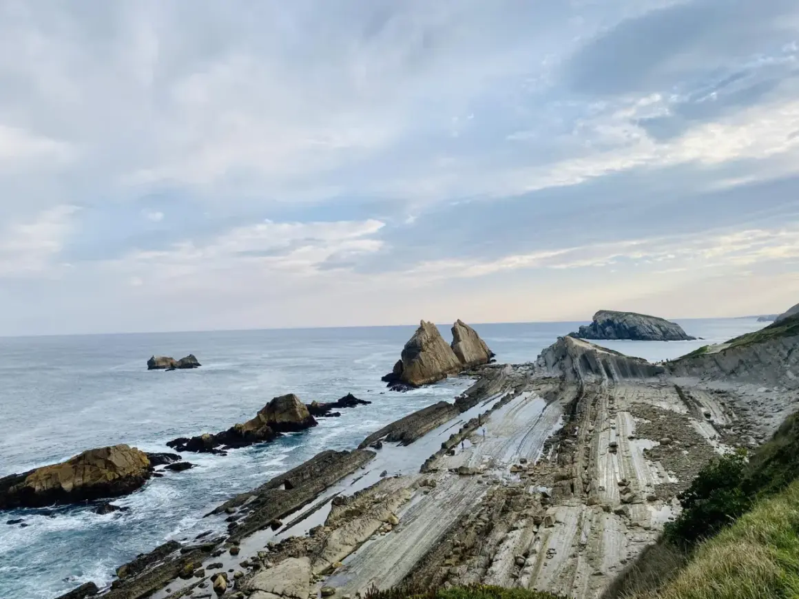 Acantilados de Liencres con formaciones rocosas únicas y el mar Cantábrico.