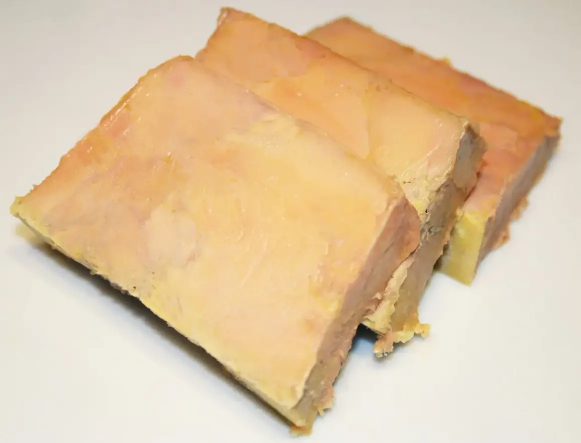Trois tranches de terrine de foie gras, préparées avec une presse, sur fond blanc.