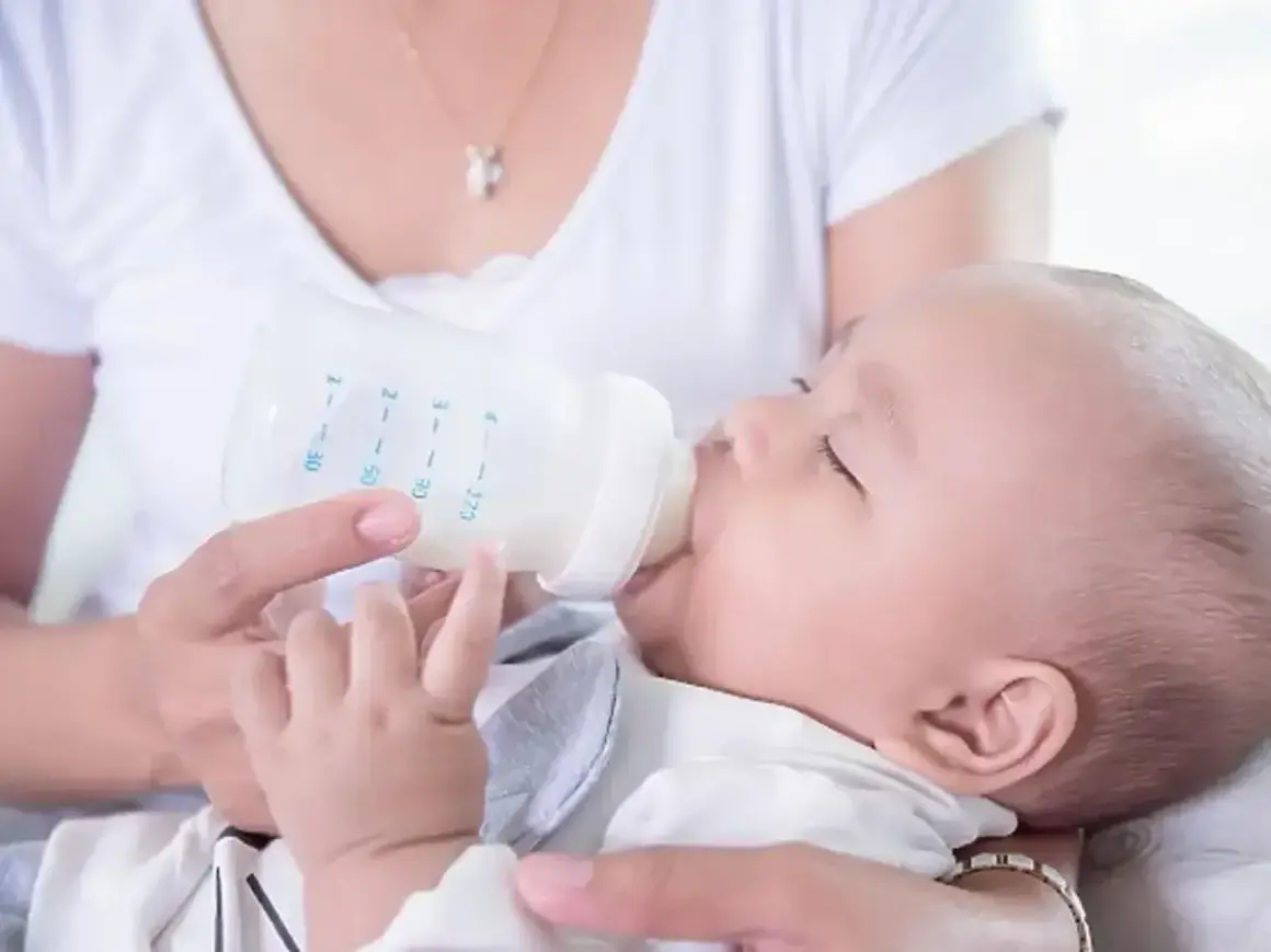 Mama karmi dziecko mlekiem z butelki. Dziecko powinno pić mleko, dopóki nie zacznie jeść stałych pokarmów.