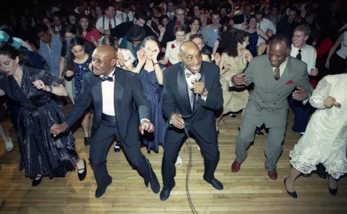 Ballerini in abiti eleganti si scatenano al ritmo della musica swing.