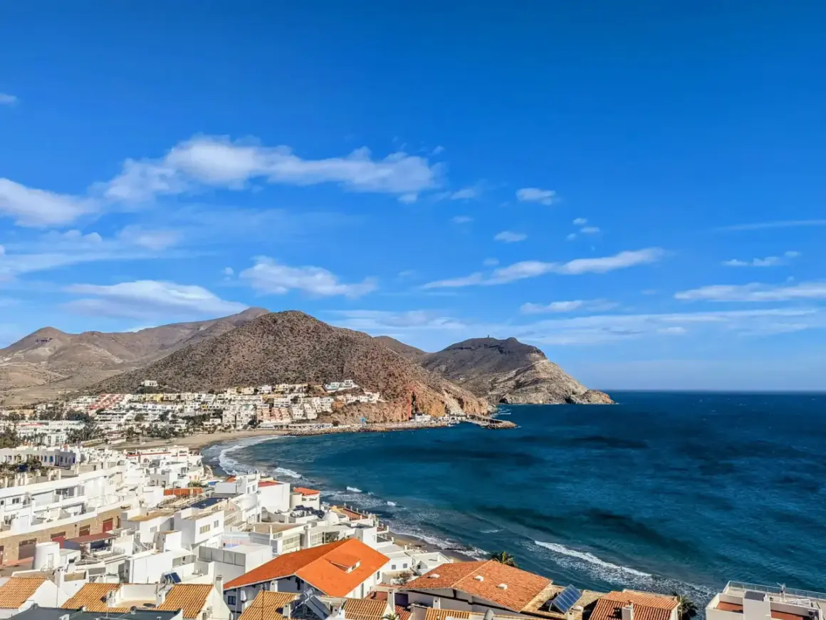 Vista panorámica de San José, Almería, con casas blancas, playa y el mar azul bajo un cielo despejado. ¡Un lugar ideal que ver en San José, Almería!