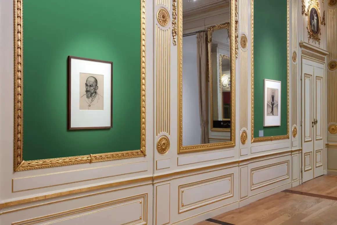 Een portret van Julie de Graag hangt aan een groene muur, naast een grote spiegel en een deur.