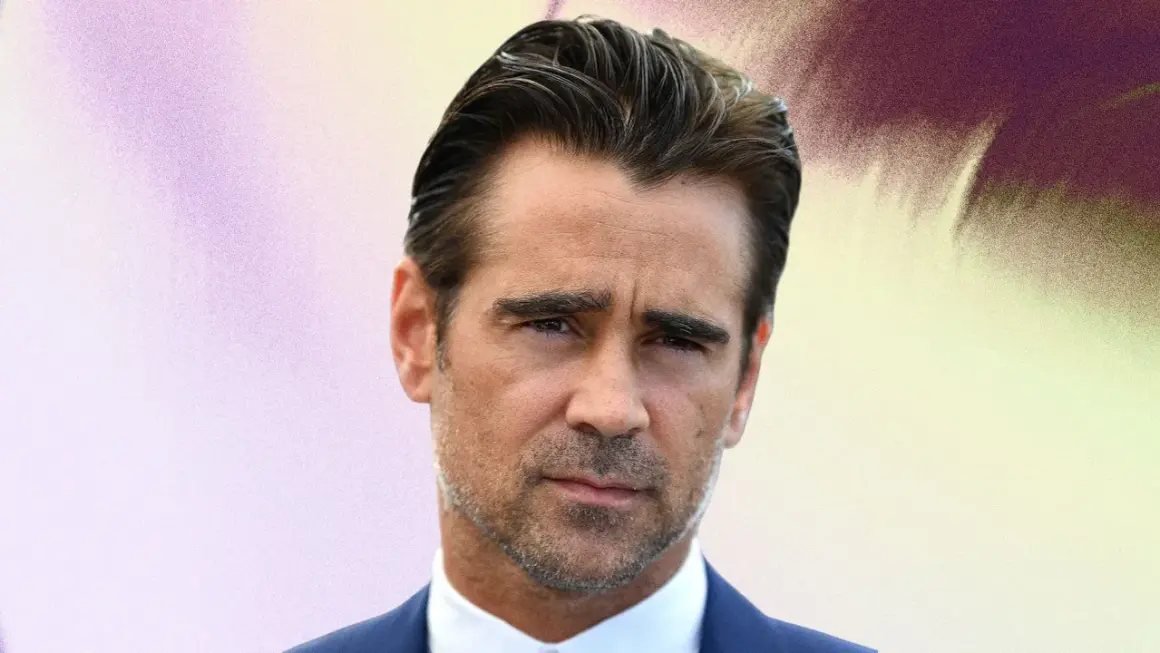 Colin Farrell med slick back-frisyr, bär en blå kostym och vit skjorta.
