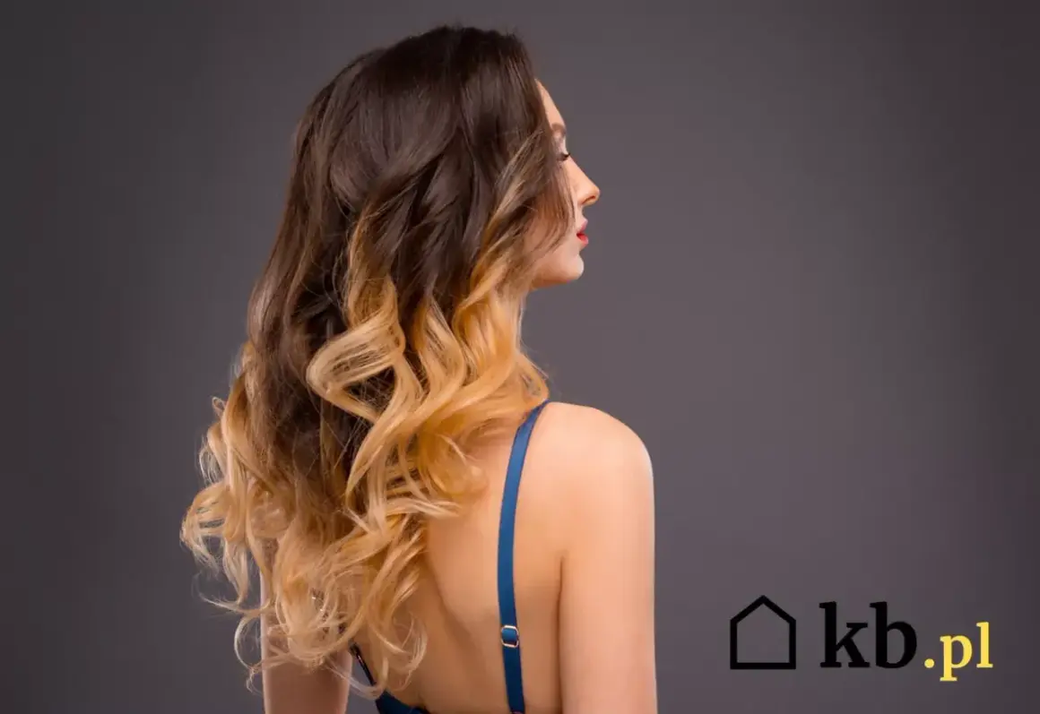 Kobieta z falowanymi włosami w stylu ombre, od ciemnego brązu po jasny blond.