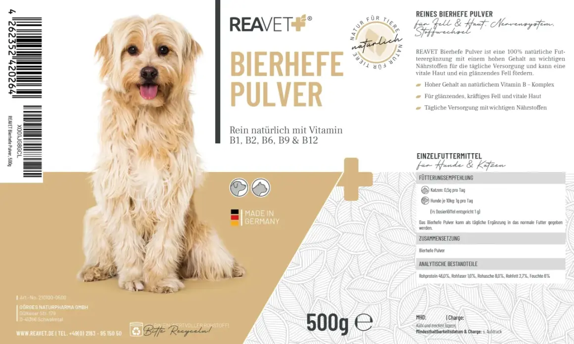 Un chien à poil long et clair, assis, avec un emballage de levure de bière pour chien et chat.