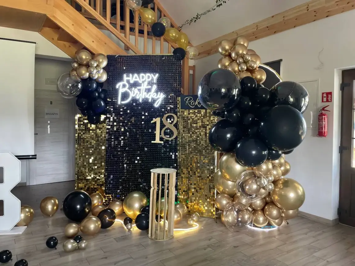 Błyszcząca ścianka z cekinów, neon "Happy Birthday", balony czarne i złote, cyfra 18.