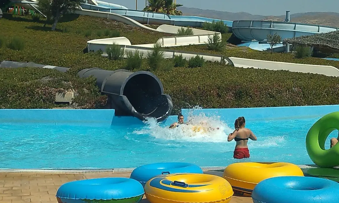 ¡Diversión en el parque Mario Park! Niños se deslizan por toboganes acuáticos y chapotean en la piscina con flotadores coloridos.