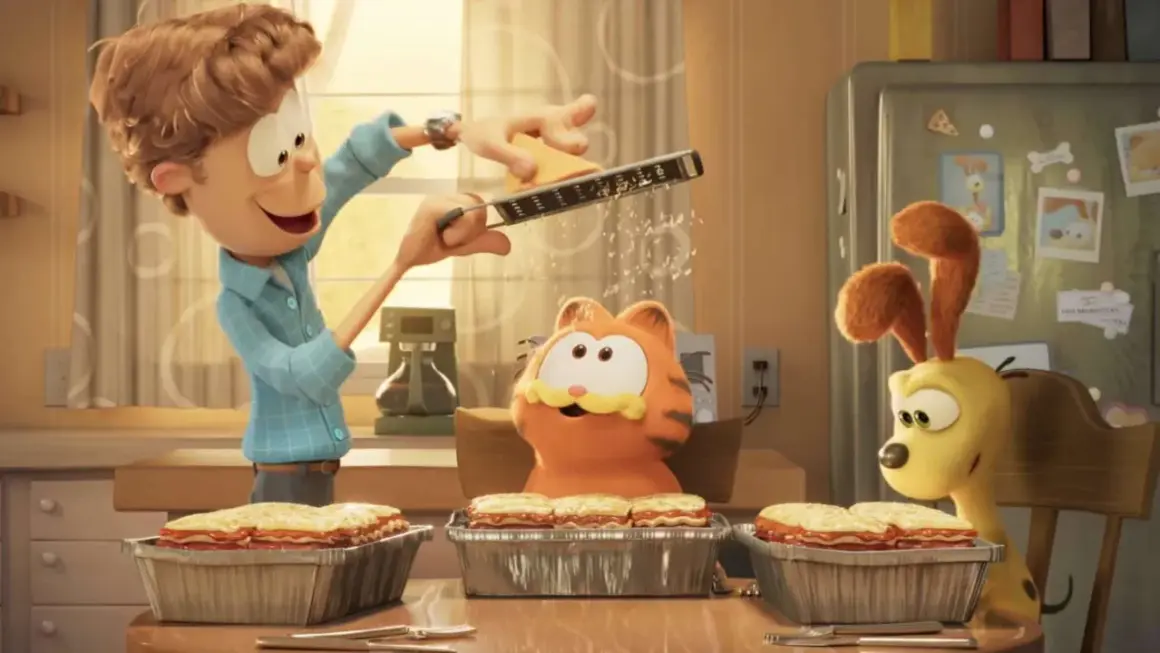 Jon reibt Käse für Lasagne, während Garfield und Odie gespannt zuschauen. Ein Festmahl für garfield – eine extra portion abenteuer!