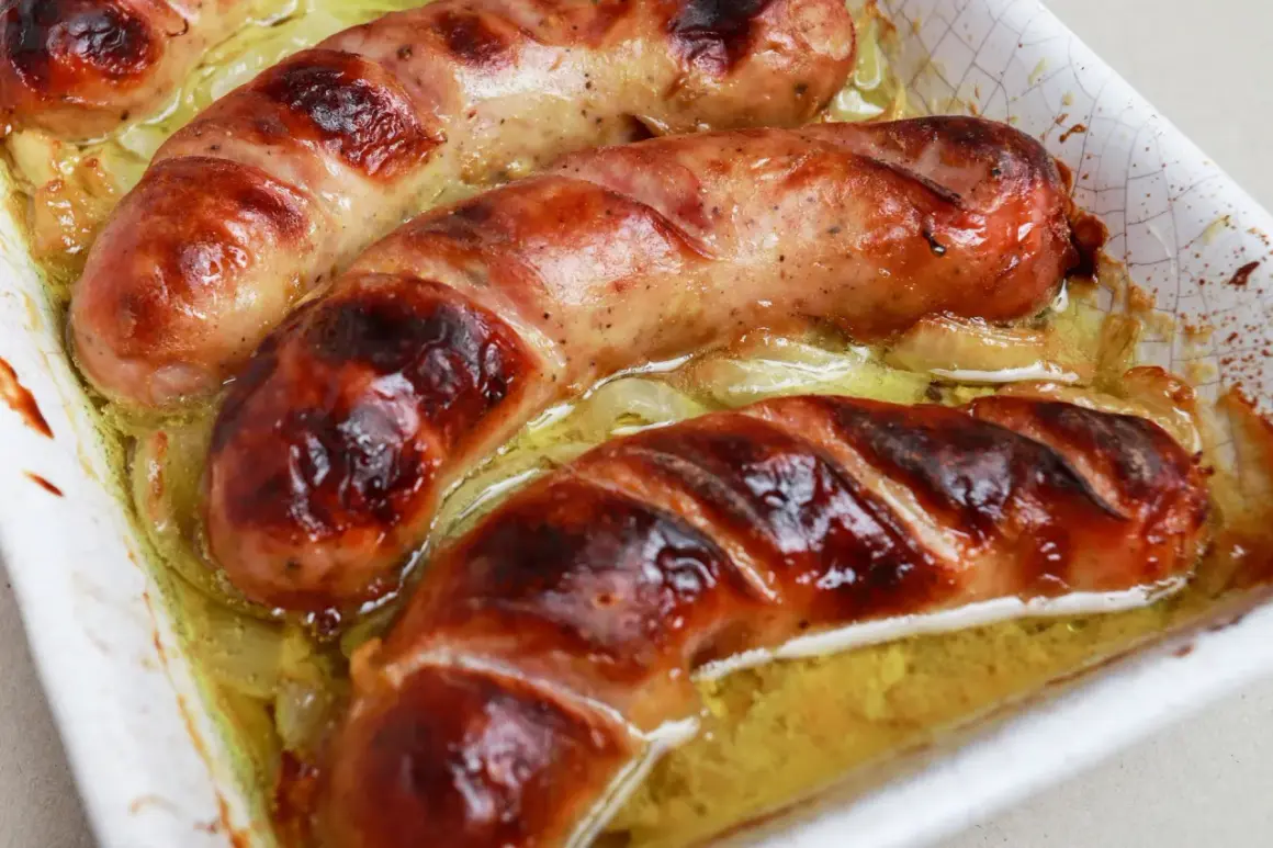Soczysta, rumiana biała kiełbasa pieczona w piekarniku, skropiona tłuszczem i podana z cebulką.