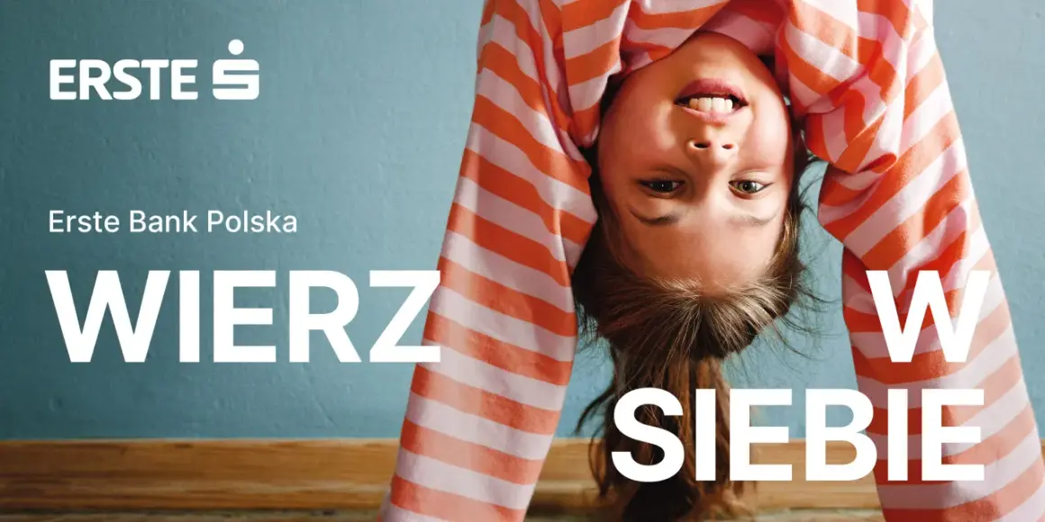 Uśmiechnięta dziewczynka w pasiastej bluzce robi mostek. Logo Erste Group i hasło "WIERZ W SIEBIE" zachęcają do wiary we własne możliwości.