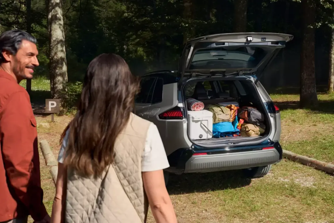 Para wycieczkowiczów podziwia bagażnik Toyoty RAV4, wypełniony po brzegi sprzętem. Imponująca pojemność bagażnika pomieści wszystko na weekendowy wypad.