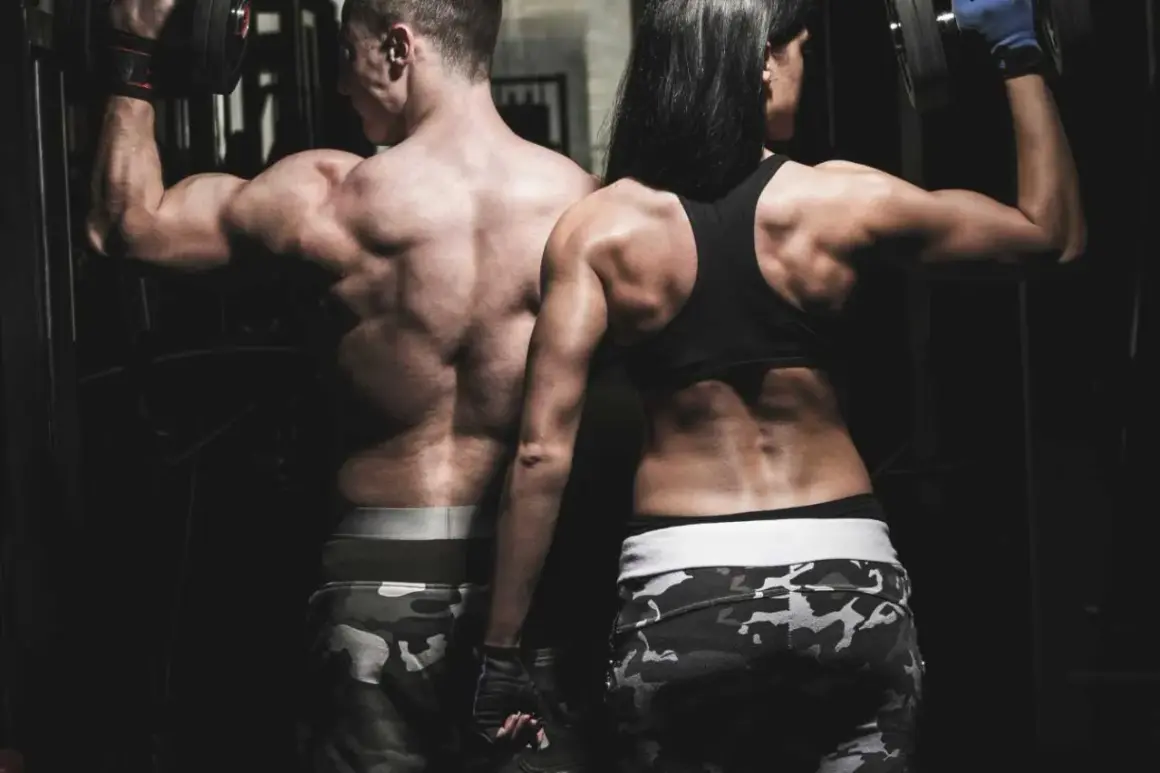 Couple s'entraînant ensemble, musculature impressionnante. L'homme et la femme font un exercice trapeze avec des haltères, montrant leur force et leur détermination.