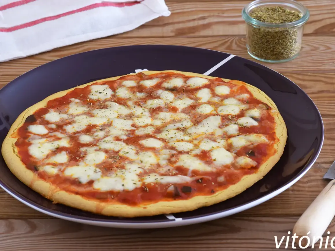 Pizza de garbanzos con queso derretido y salsa de tomate, lista para disfrutar.