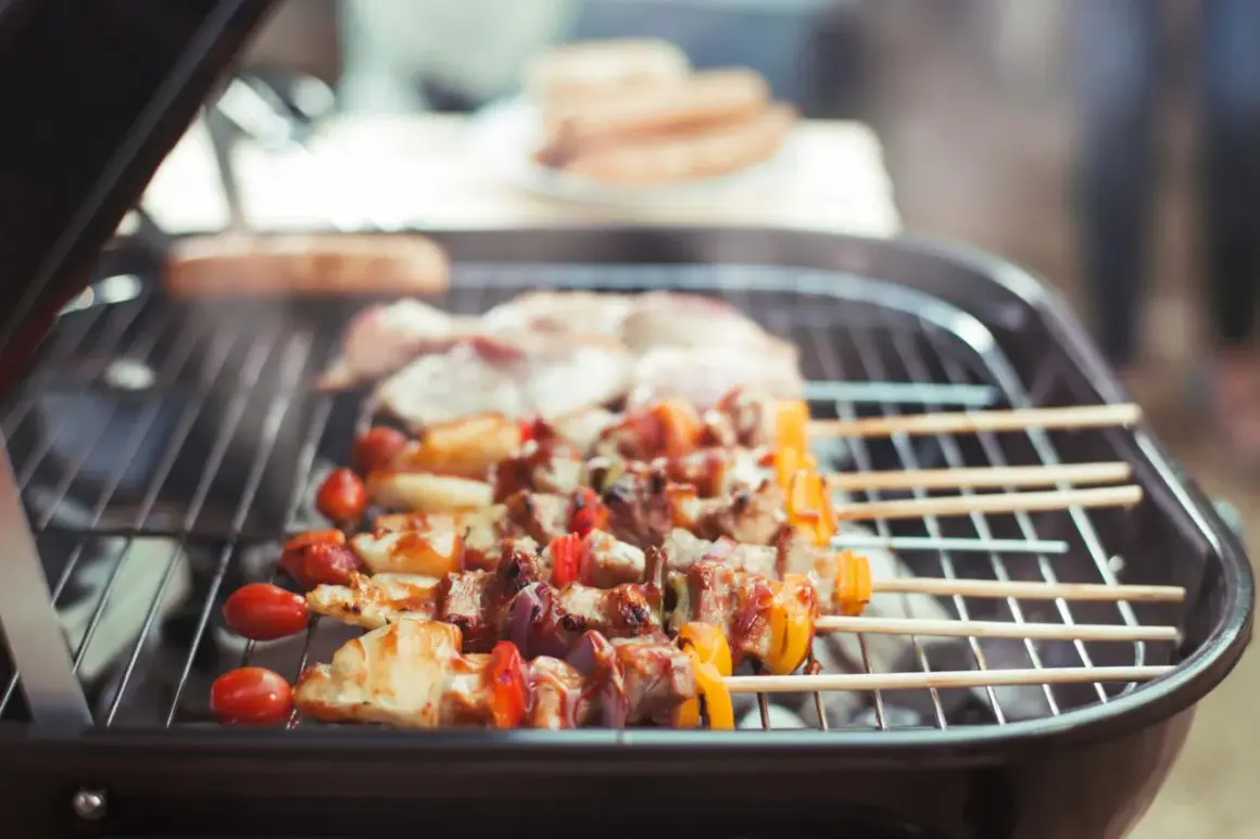 Fleischspieße mit Gemüse brutzeln auf einem Grill. Ein gemütliches Grillen in der Wohnung, auch bei schlechtem Wetter.