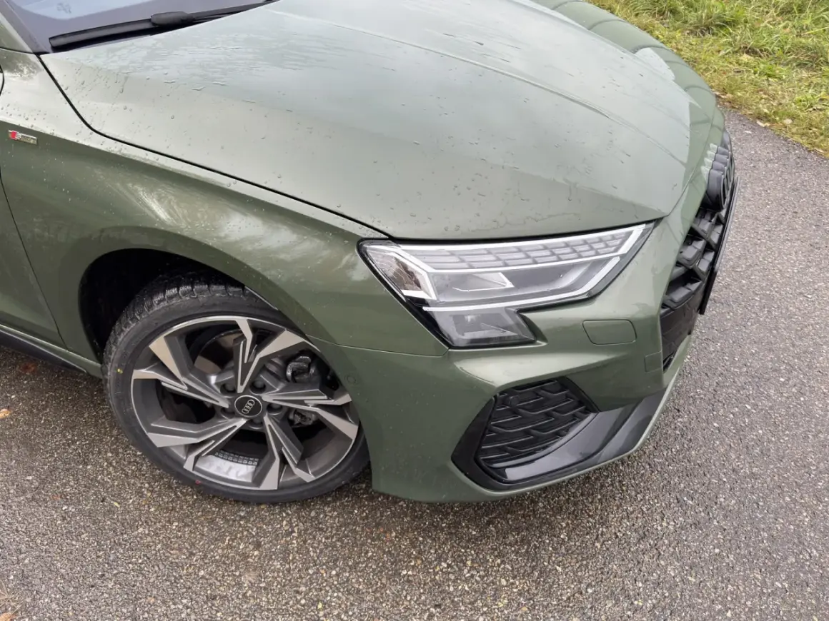 Zielony Audi A3 kombi z felgami S line na mokrej drodze.