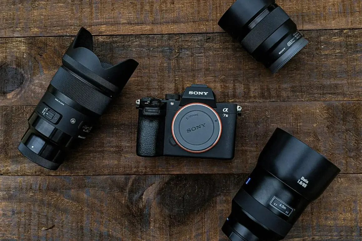 Aparat Sony Alpha 7 III z obiektywami na drewnianym tle.