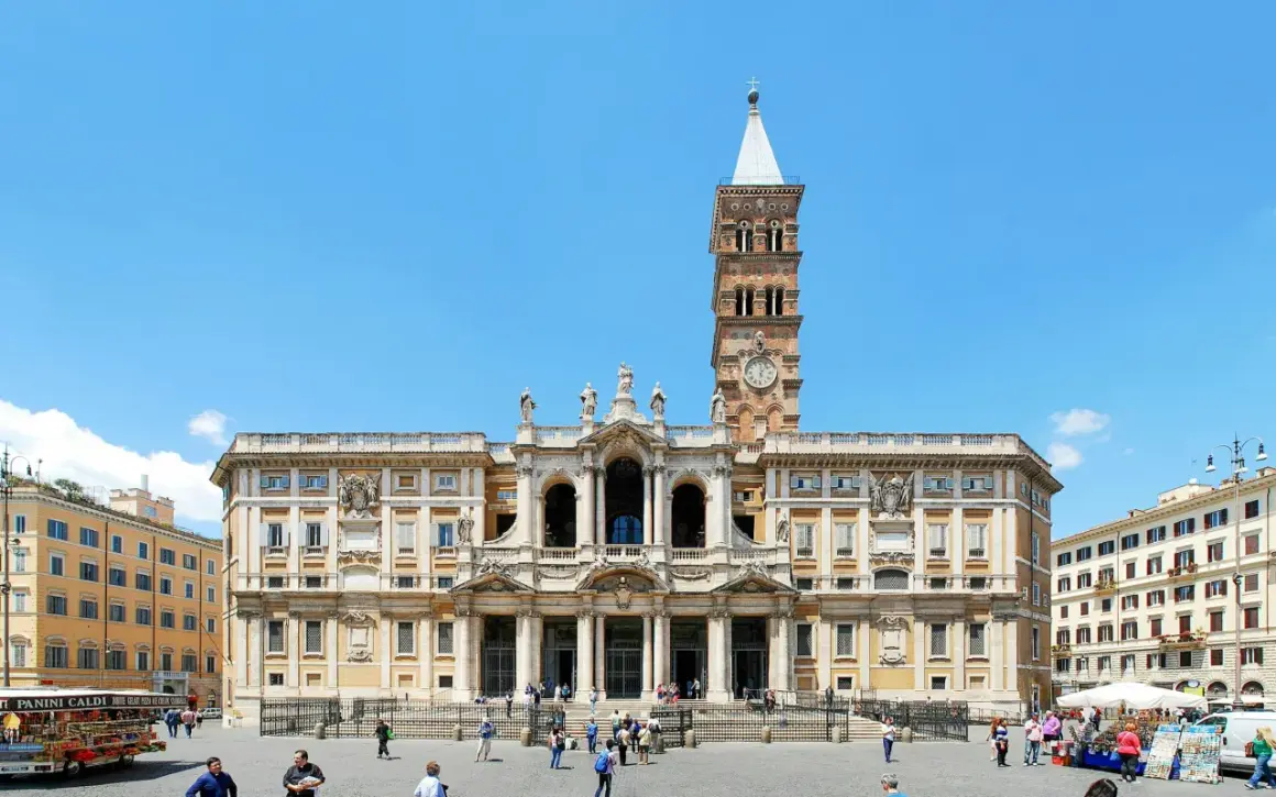 Bazylika Santa Maria Maggiore w Rzymie, z charakterystyczną wieżą zegarową, na tle błękitnego nieba.