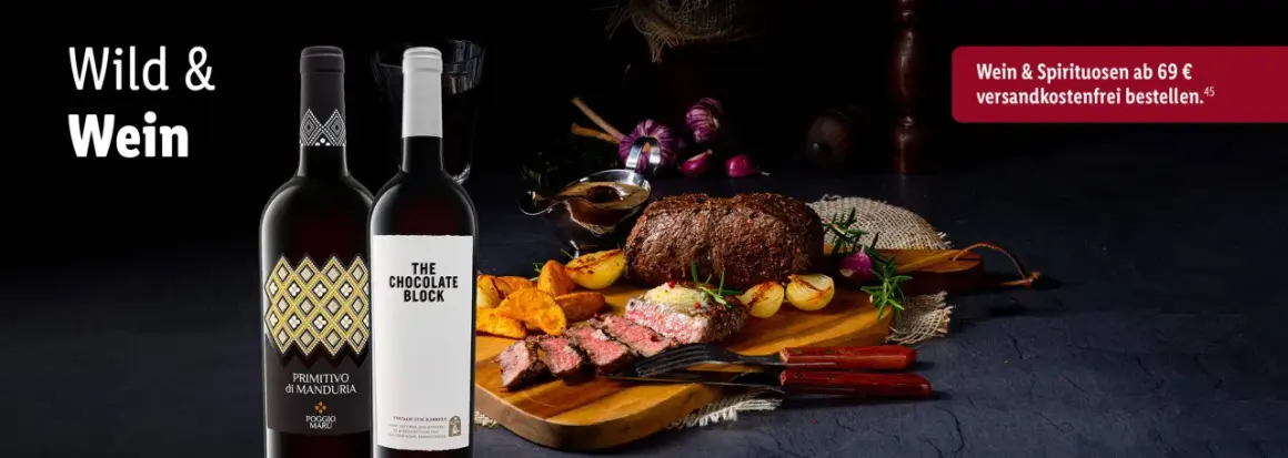 Zwei Flaschen Rotwein neben einem saftigen Wildbraten mit Beilagen. Perfekt, um die Frage zu beantworten: welcher rotwein zum wild kochen.