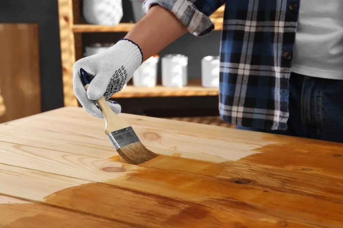 Application d'une première couche de vernis sur un plateau en bois. On se demande combien de couche de vernis bois seront nécessaires pour un fini parfait.