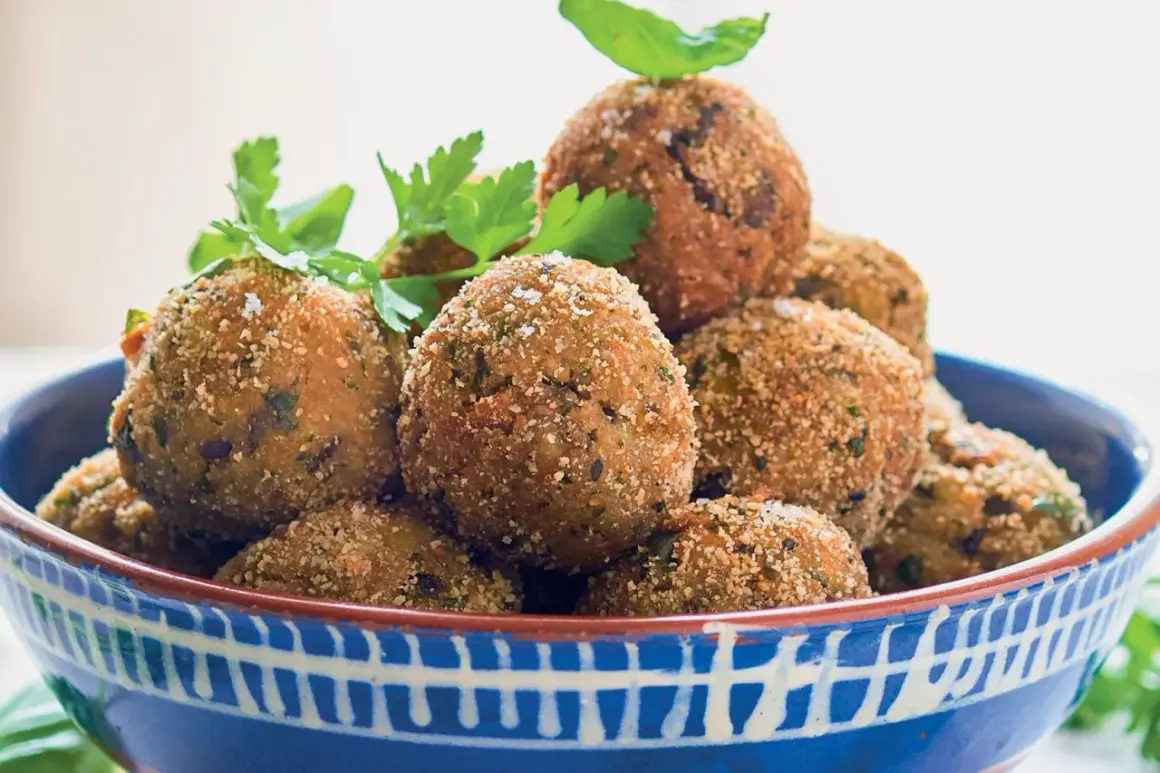 Polpette di melanzane siciliane dorate e croccanti, guarnite con prezzemolo fresco, in una ciotola blu decorata.
