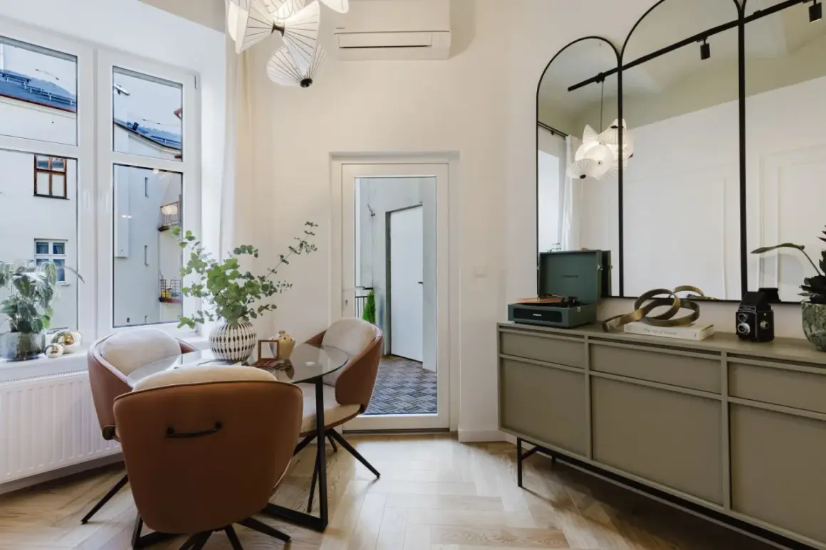 Eleganckie lustra w stylu retro nad komodą z gramofonem i książkami.