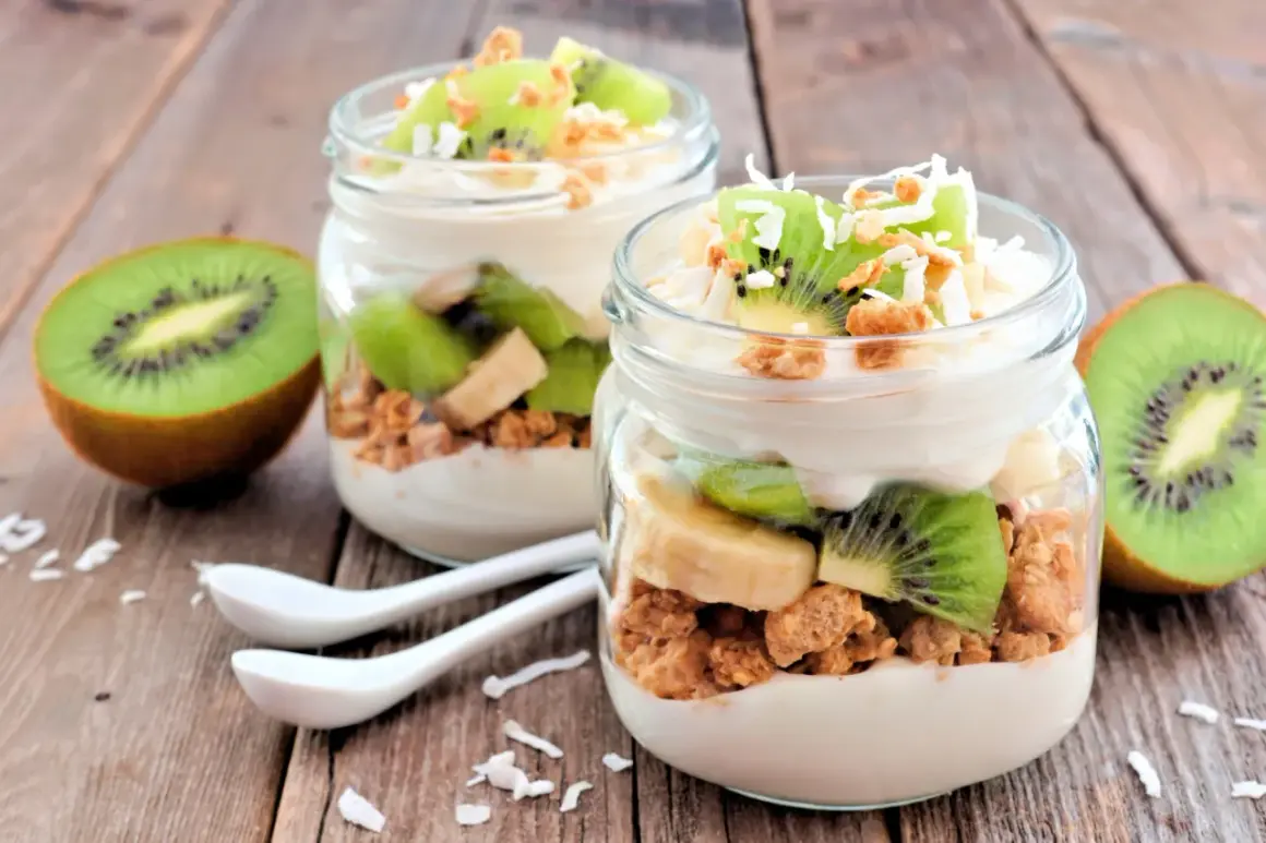 Två glas med yoghurt, granola, kiwi och banan. Perfekt mellanmål att ta med.