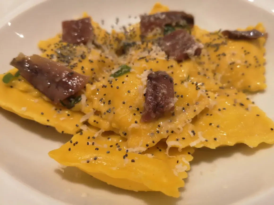 Ravioli gialli con acciughe e semi di papavero, un piatto da provare alla trattoria da me Bologna.