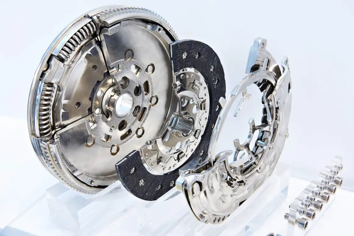Rozłożony na części koło dwumasowe, tarcza sprzęgła i docisk. To kluczowe elementy układu przeniesienia napędu w samochodzie.