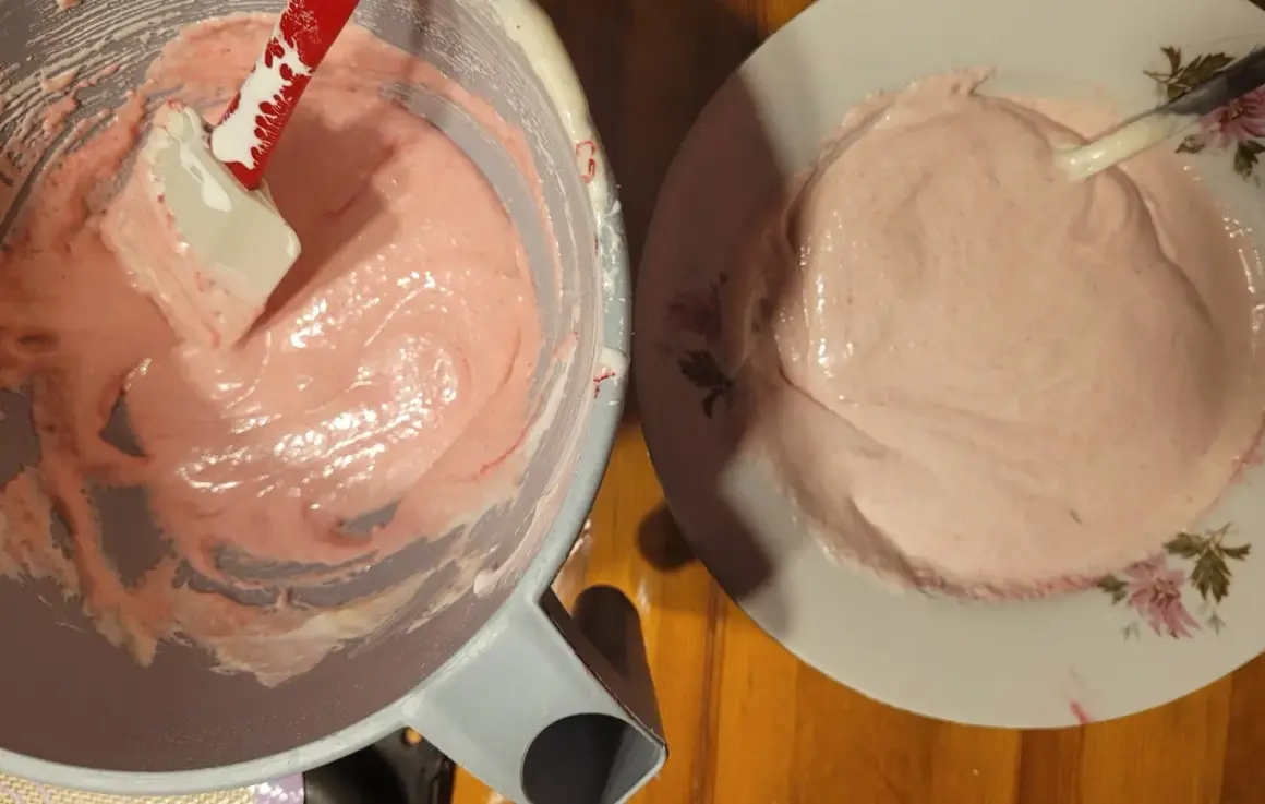Różowa masa na makaroniki francuskie w misce i na talerzyku.