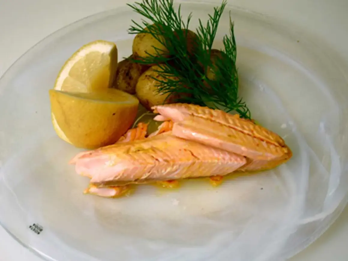 Hel regnbåge i ugn, serverad med småpotatis, citron och dill. En vacker och smakrik rätt.