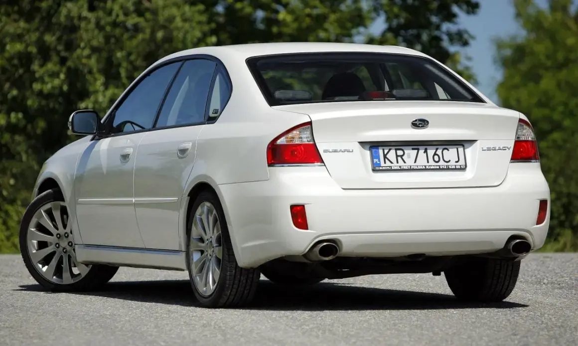 Biały Subaru Legacy z tablicą KR 716CJ.