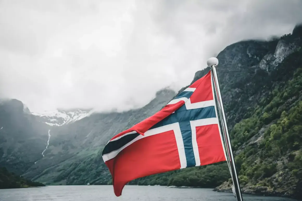 Norwegia: malownicze fiordy i wysokie norwegia zarobki netto. Flaga powiewa na maszcie, zapraszając do odkrywania piękna i możliwości.