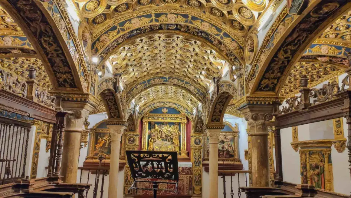 Interior de una capilla ricamente decorada con techos abovedados dorados y azules, pinturas y un altar. Caminos de pasión que invitan a la contemplación.
