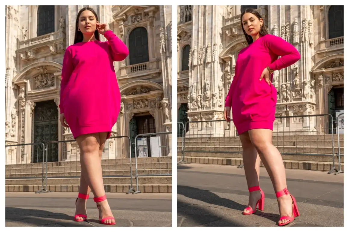 Modelka w różowej sukience dresowej plus size, prezentująca wygodę i styl na tle zabytkowej architektury.