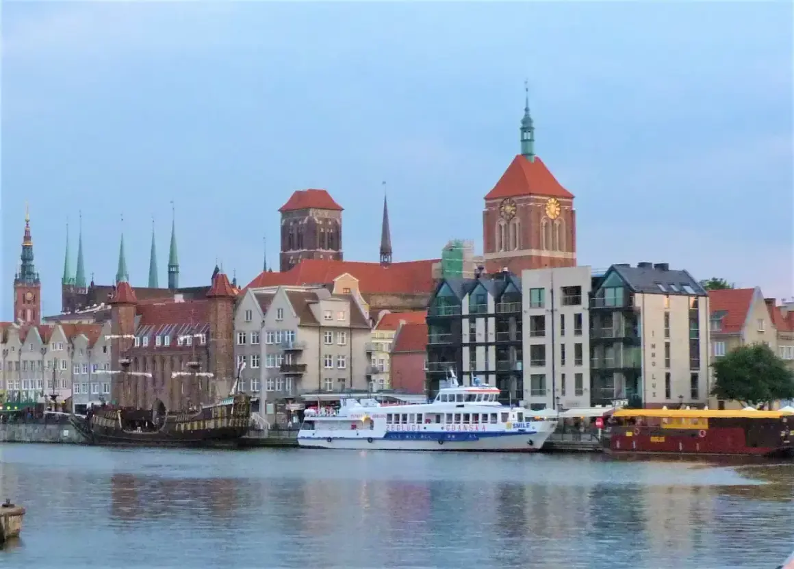 Statek wycieczkowy "Gryf" płynie przez Gdańsk, mijając zabytkowe kamienice i kościoły.