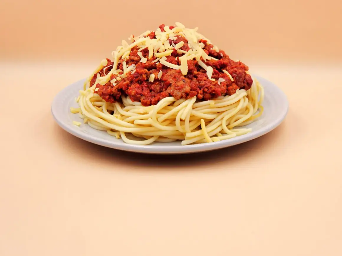 Pyszne spaghetti z sosem bolońskim i startym serem. Idealne danie, gdy zastanawiasz się, jak zrobić spaghetti.