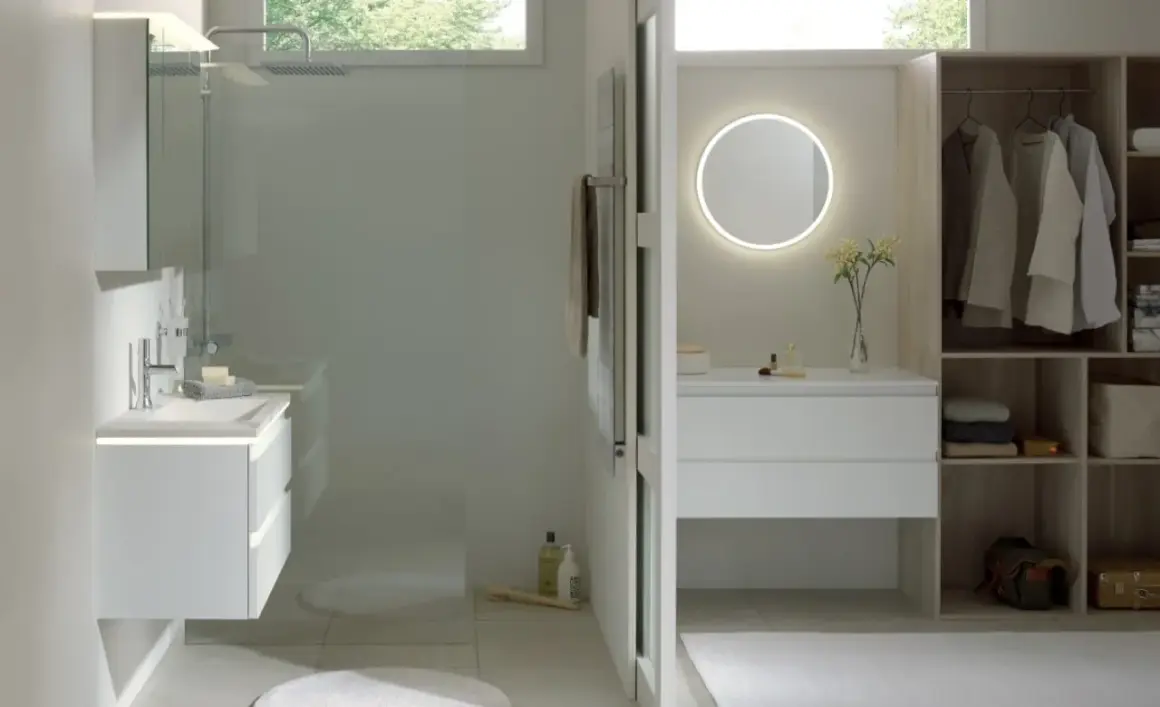 Salle de bain moderne avec douche, meuble vasque, miroir lumineux et dressing ouvert.