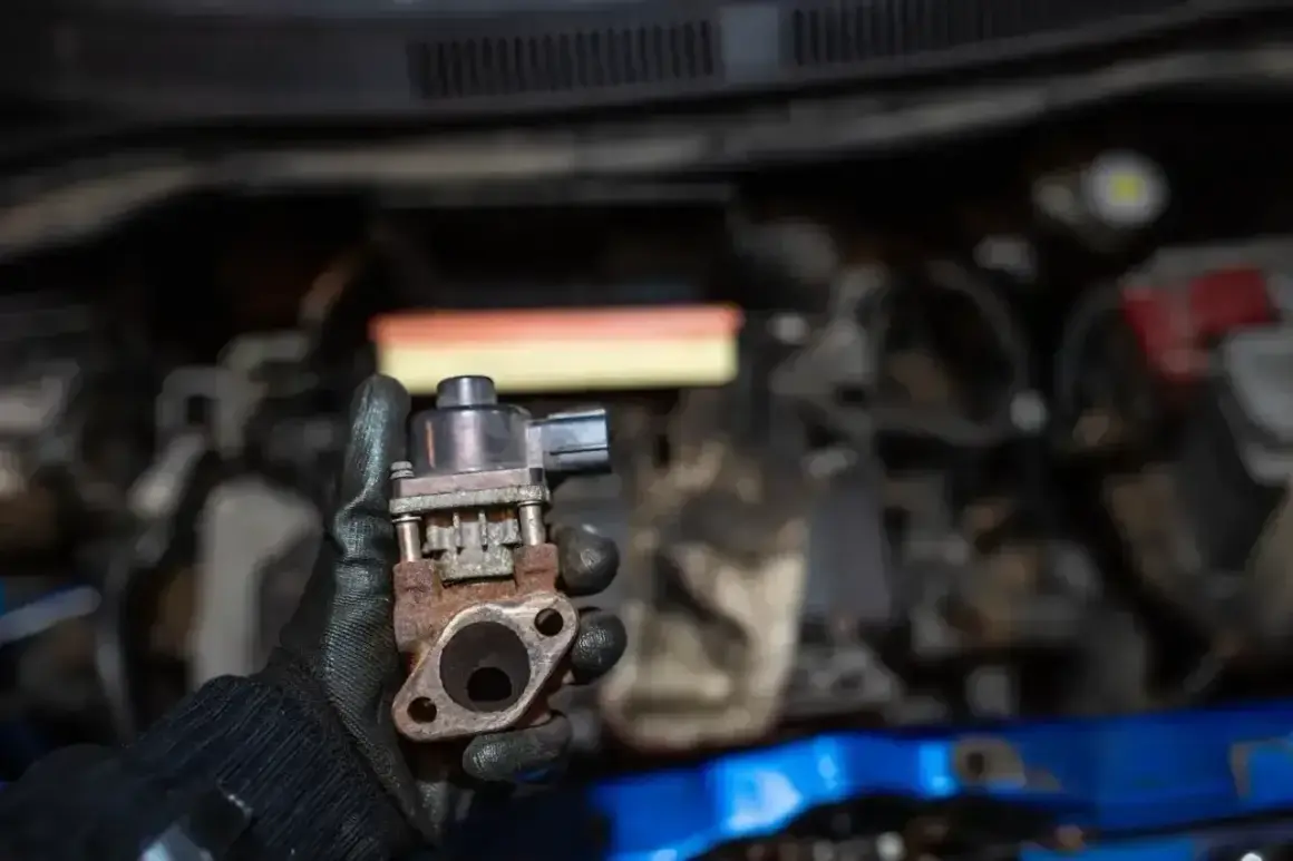 Zardzewiały zawór EGR w dłoni mechanika, gotowy do montażu w silniku.