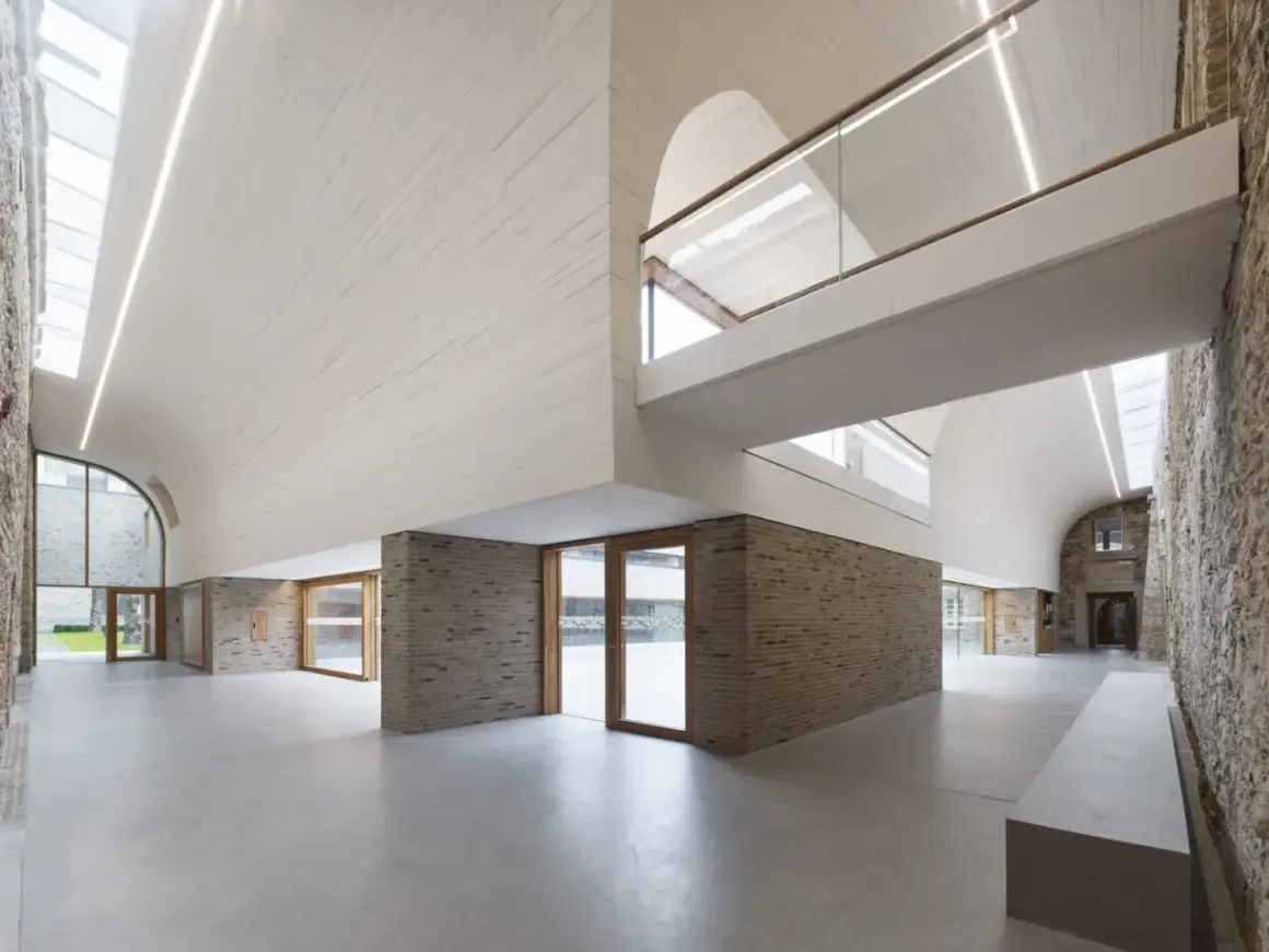 Modernes Haus Altenberg mit geschwungener Decke, Ziegelwänden und viel Glas.